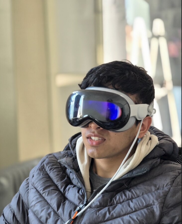 Aarohan wearing an Apple Vision Pro, half-smiling