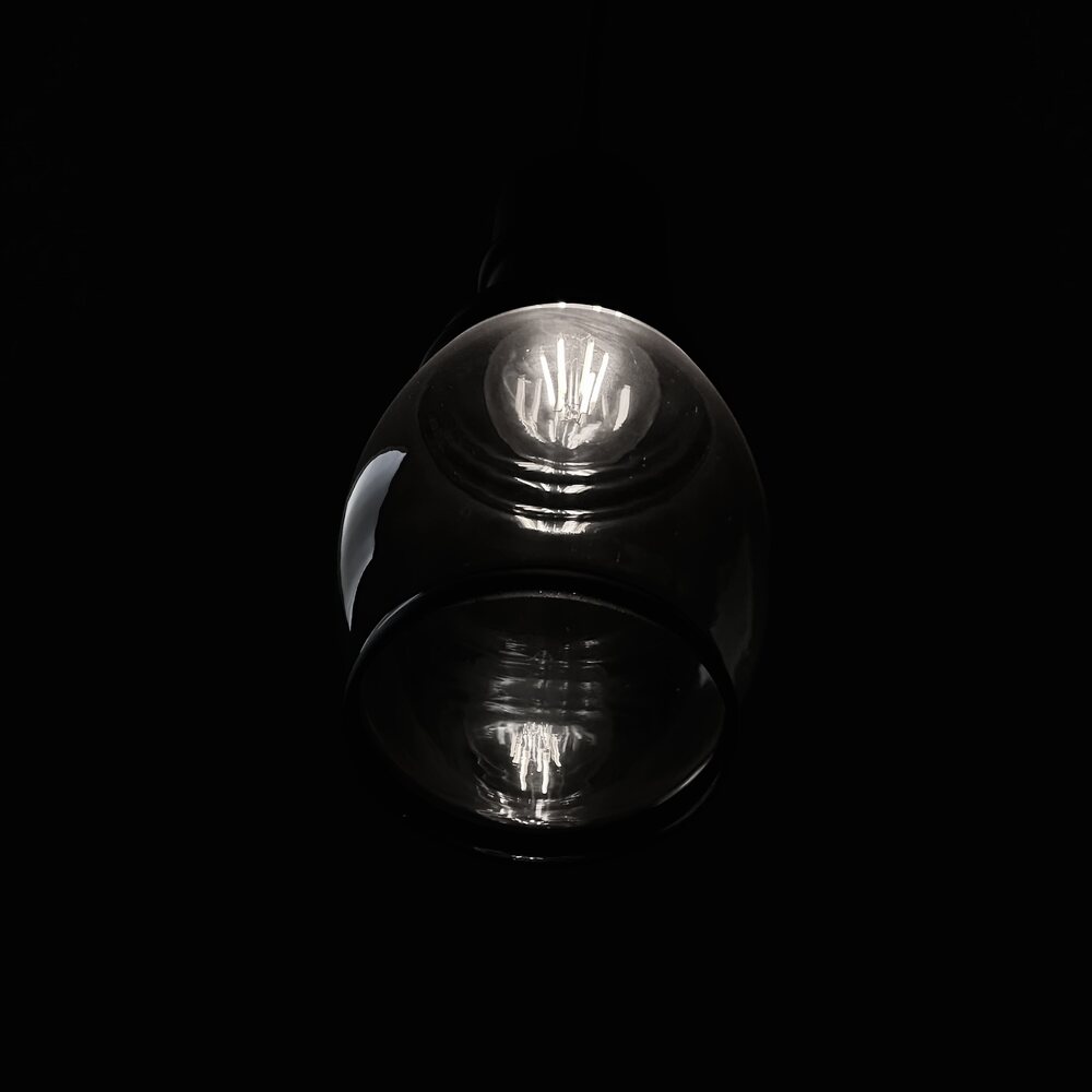 A glass sphere catching a single highlight against black