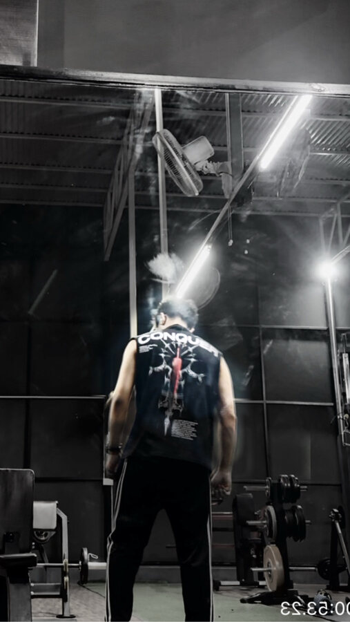 Aarohan from behind under the gym strip lights