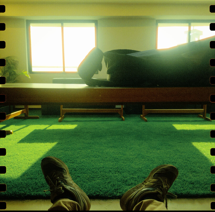 Boots up on green turf in a yellow room