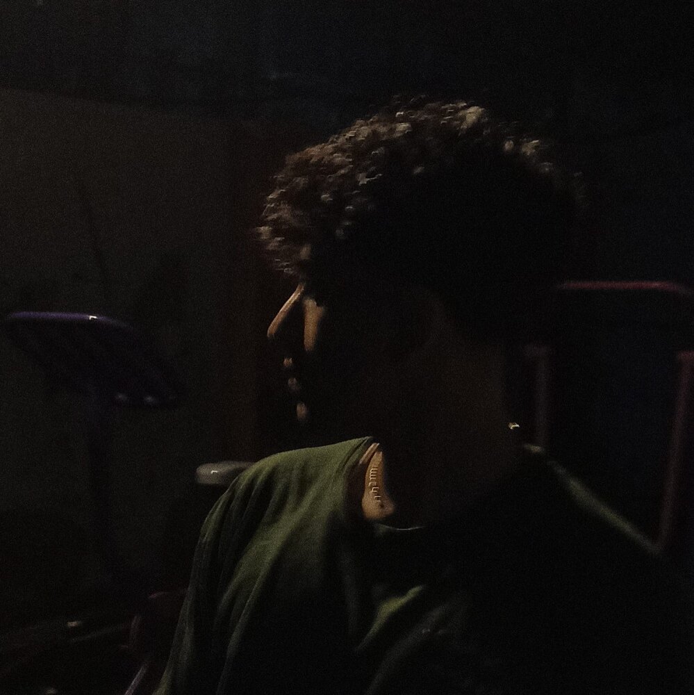 Aarohan in near darkness, lit by one dim source